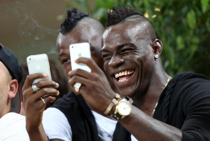 Mario Balotelli e il fratello Enock Barwuah in tribuna a San Siro per Milan-Sampdoria. I due se la ridono mentre scattano foto con lo smartphone. Ansa